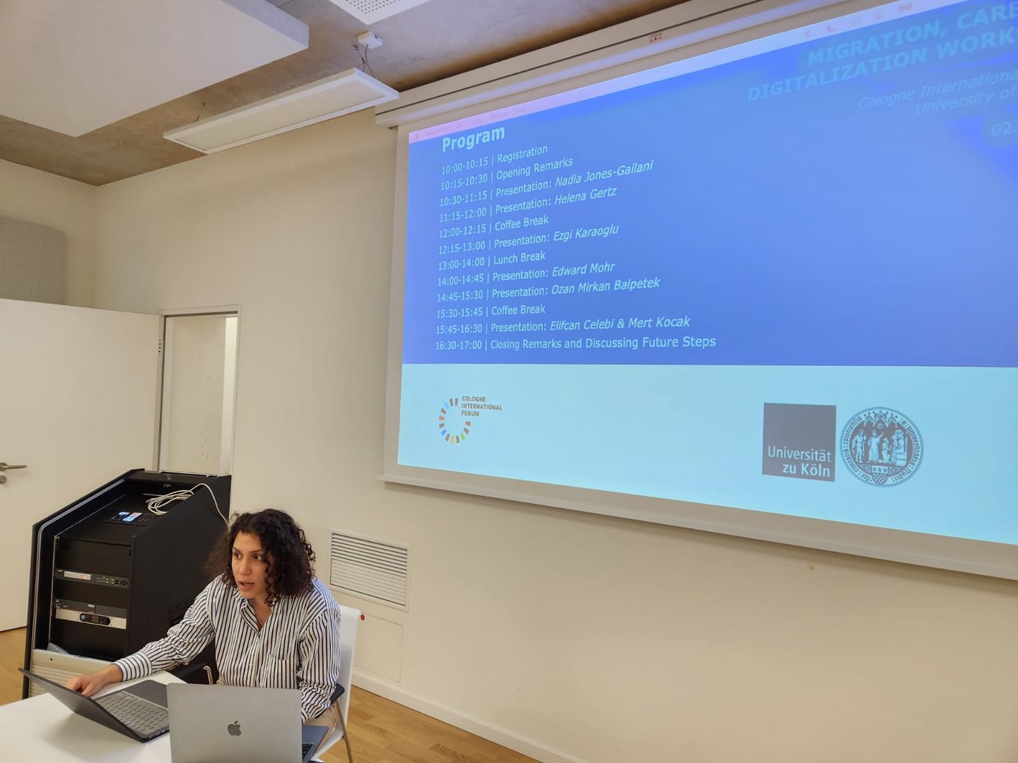 Woman sitting in front of a presentation screen.