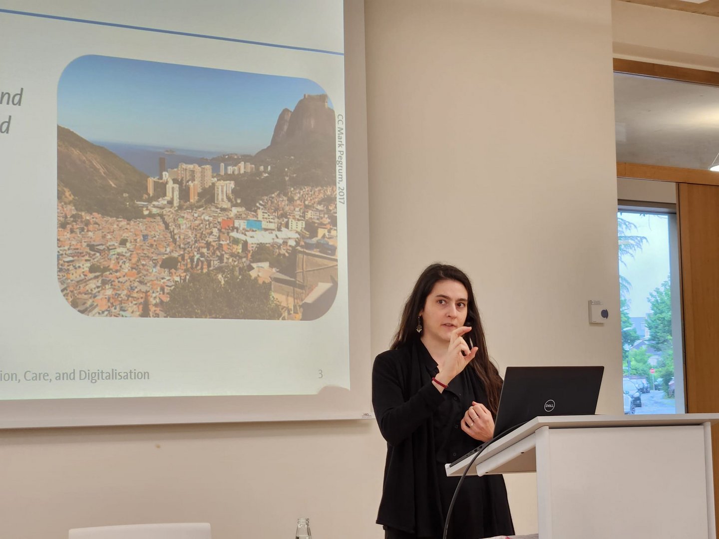 Woman standing in front of a presentation screen.