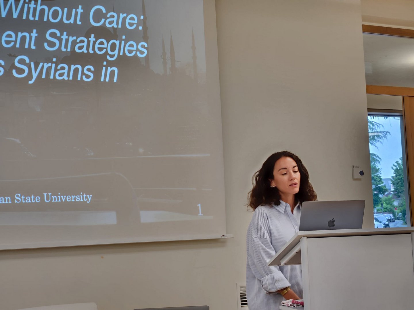 Woman standing in front of a presentation screen.